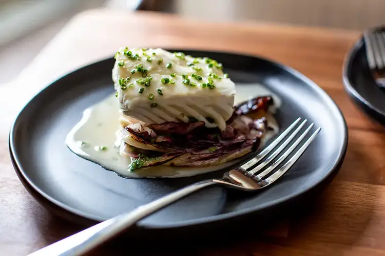 A plated setting of beautifully garnished halibut.