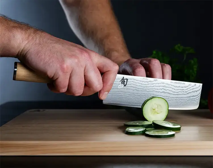 A Classic Blonde Nakiri slices a cucumber.