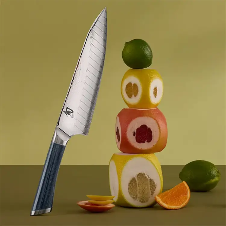 Shun Shiranami 8-inch chef’s knife with Damascus blade beside stacked citrus fruits