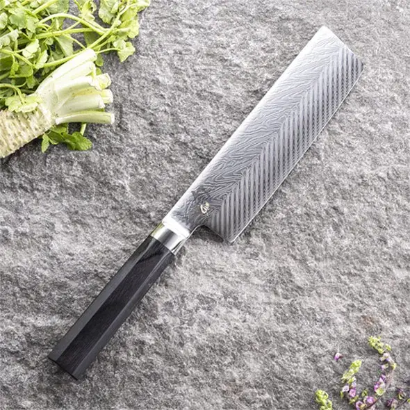 Nakiri knife in use slicing vegetables on a cutting board.