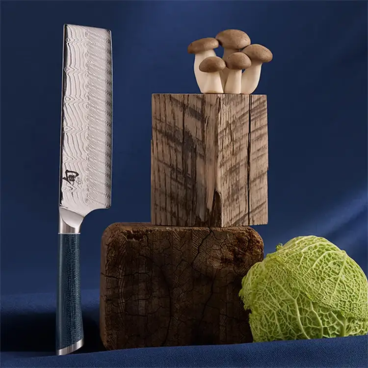 Shun Shiranami 6.5-inch nakiri vegetable knife with Damascus blade beside cabbage and mushrooms